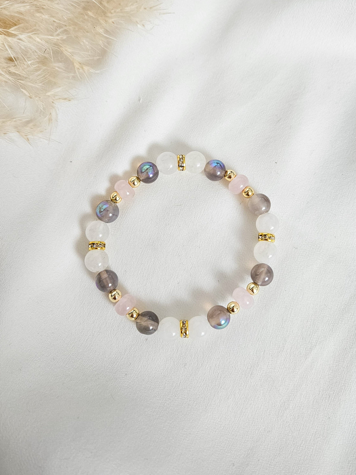 Beaded bracelet with gold accents on a white surface