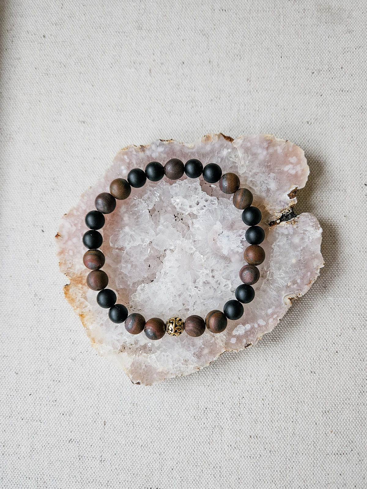 Beaded bracelet on a rough stone surface with a neutral background