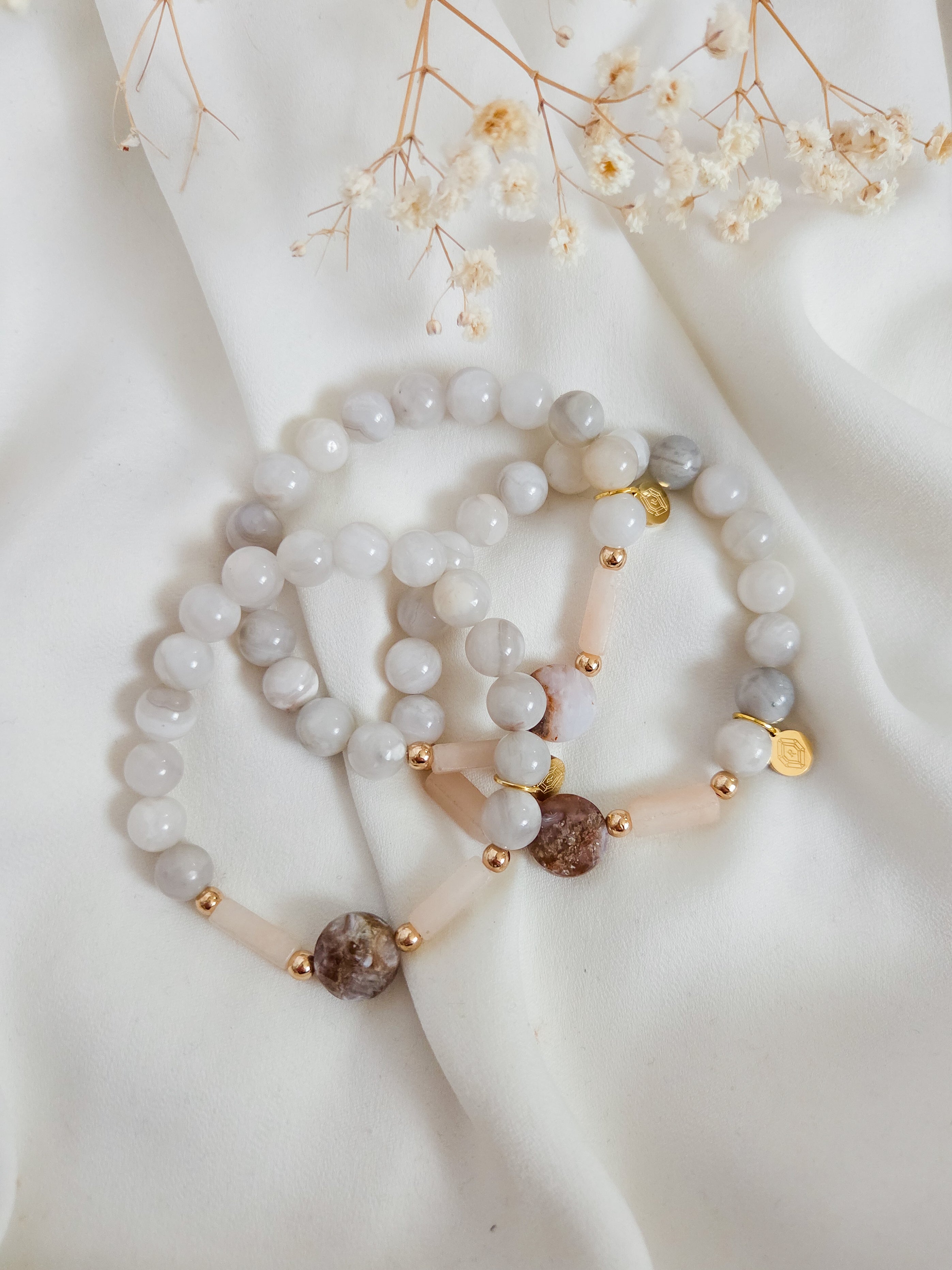 Beaded gemstone stacking bracelet with gold accents on a white fabric background. Made in Canada.