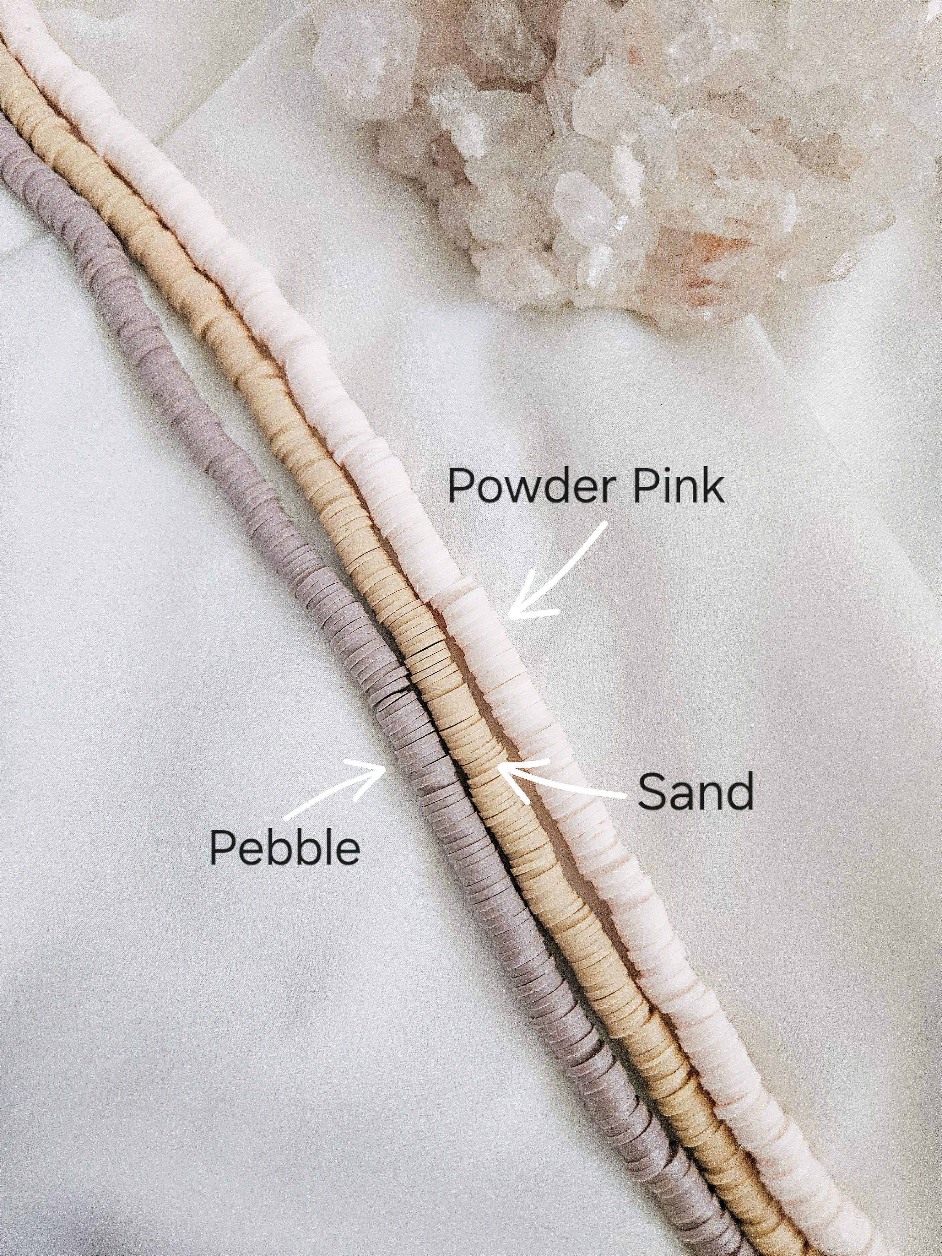 Polymer clay heishi beads in powder pink, sand, and pebble.